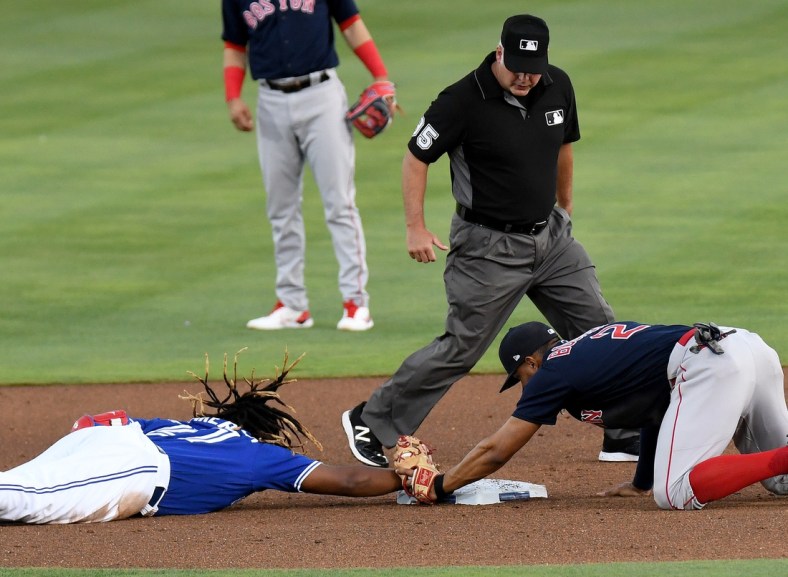 May 19, 2021; Dunedin, Florida, CAN; Toronto Blue Jays infielder Vladimir Guerrero Jr. (27) dives back to second base as Boston Red Sox infielder Xander Bogaerts (2) attempts a tag in the first inning  at TD Ballpark. Mandatory Credit: Jonathan Dyer-USA TODAY Sports