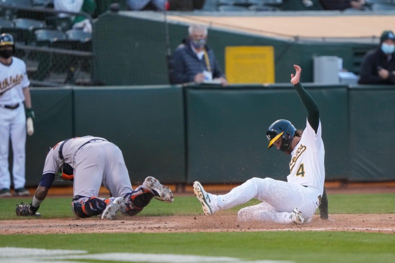 May 19, 2021; Oakland, California, USA;  Oakland Athletics third baseman Chad Pinder (4) slides home during the second inning against the Houston Astros at RingCentral Coliseum. Mandatory Credit: Stan Szeto-USA TODAY Sports