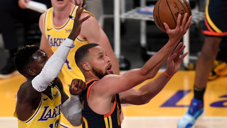 May 19, 2021; Los Angeles, California, USA;   Golden State Warriors guard Stephen Curry (30) gets past Los Angeles Lakers guard Dennis Schroder (17) and Los Angeles Lakers guard Alex Caruso (4) as he drives to the basket in the first half of the game at Staples Center. Mandatory Credit: Jayne Kamin-Oncea-USA TODAY Sports