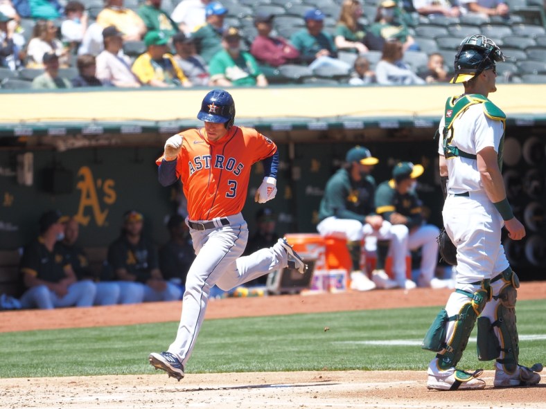 May 20, 2021; Oakland, California, USA; Houston Astros center fielder Myles Straw (3) scores a run behind Oakland Athletics catcher Sean Murphy (12) during the third inning at RingCentral Coliseum. Mandatory Credit: Kelley L Cox-USA TODAY Sports
