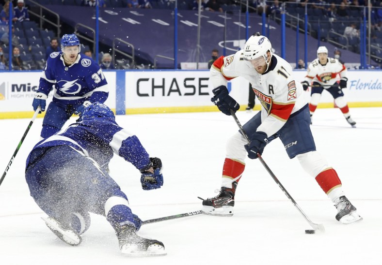 May 20, 2021; Tampa, Florida, USA; Florida Panthers left wing Jonathan Huberdeau (11) shoots the puck as Tampa Bay Lightning defenseman Erik Cernak (81) defends the shot during the second period in game three of the first round of the 2021 Stanley Cup Playoffs at Amalie Arena. Mandatory Credit: Kim Klement-USA TODAY Sports