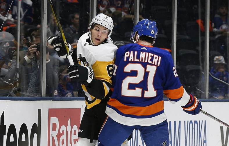 May 20, 2021; Uniondale, New York, USA; Pittsburgh Penguins defenseman John Marino (6) is checked into the boards by New York Islanders left wing Kyld Palmieri (21) during the second period in game three of the first round of the 2021 Stanley Cup Playoffs at Nassau Veterans Memorial Coliseum. Mandatory Credit: Andy Marlin-USA TODAY Sports
