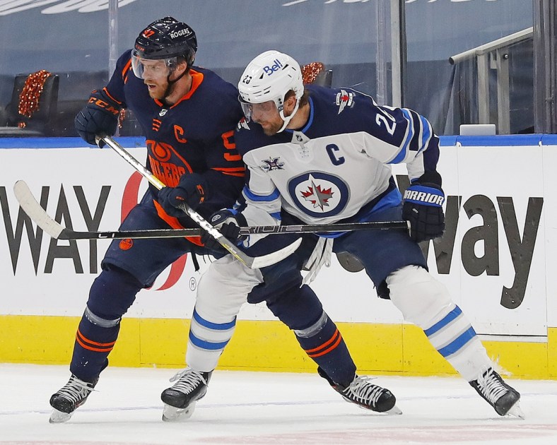 May 21, 2021; Edmonton, Alberta, CAN; Edmonton Oilers forward Connor McDavid (97) and Winnipeg Jets forward Blake Wheeler (26) battle for position during the first period in game two of the first round of the 2021 Stanley Cup Playoffs at Rogers Place. Mandatory Credit: Perry Nelson-USA TODAY Sports