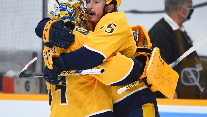 May 21, 2021; Nashville, Tennessee, USA; Nashville Predators center Matt Duchene (95) celebrates with goaltender Juuse Saros (74) after scoring the game-winning goal in the second overtime against the Carolina Hurricanes in game three of the first round of the 2021 Stanley Cup Playoffs at Bridgestone Arena. Mandatory Credit: Christopher Hanewinckel-USA TODAY Sports