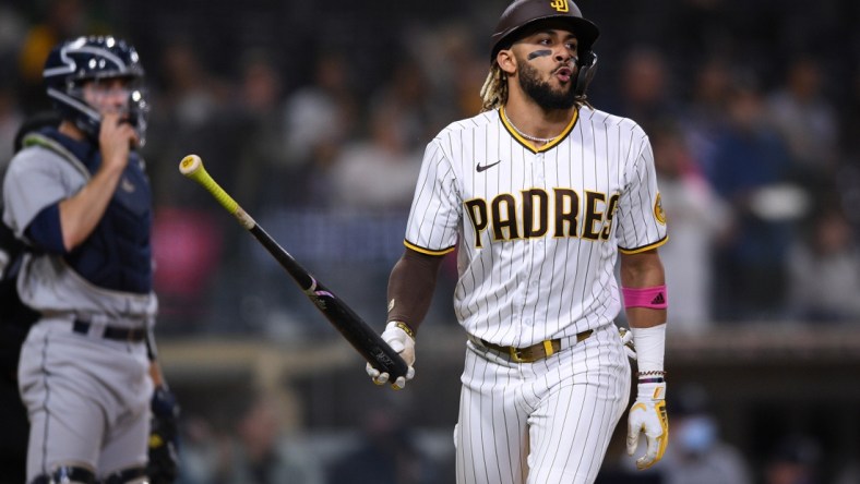 May 21, 2021; San Diego, California, USA; San Diego Padres shortstop Fernando Tatis Jr. (right) tosses his bat after hitting a three-run home run during the second inning as Seattle Mariners catcher Tom Murphy (left) looks on at Petco Park. Mandatory Credit: Orlando Ramirez-USA TODAY Sports