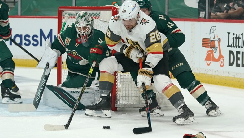 May 22, 2021; Saint Paul, Minnesota, USA; Vegas Golden Knights left wing William Carrier (28) protects the puck from Minnesota Wild center Nick Bonino (13) in front of Minnesota goaltender Cam Talbot (33) during the first period in game four of the first round of the 2021 Stanley Cup Playoffs at Xcel Energy Center. Mandatory Credit: Nick Wosika-USA TODAY Sports