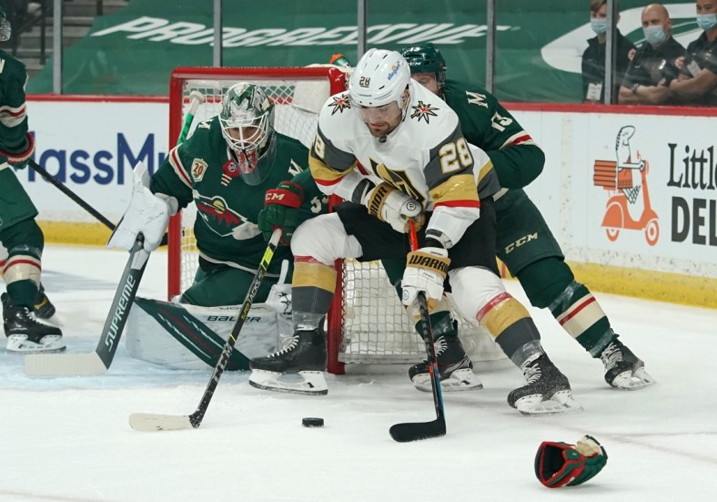May 22, 2021; Saint Paul, Minnesota, USA; Vegas Golden Knights left wing William Carrier (28) protects the puck from Minnesota Wild center Nick Bonino (13) in front of Minnesota goaltender Cam Talbot (33) during the first period in game four of the first round of the 2021 Stanley Cup Playoffs at Xcel Energy Center. Mandatory Credit: Nick Wosika-USA TODAY Sports