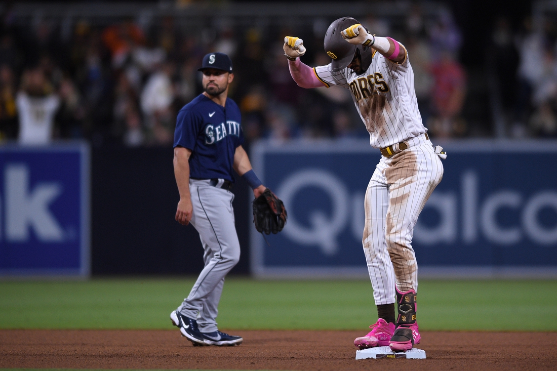 May 22, 2021; San Diego, California, USA; San Diego Padres shortstop Fernando Tatis Jr. (right) reacts on second base after hitting a double during the seventh inning as Seattle Mariners second baseman Jack Mayfield (left) looks on at Petco Park. Mandatory Credit: Orlando Ramirez-USA TODAY Sports