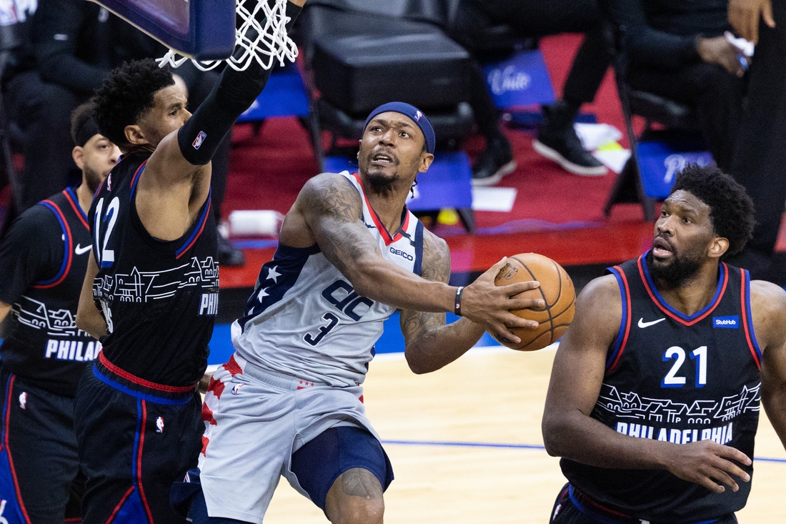 May 23, 2021; Philadelphia, Pennsylvania, USA; Washington Wizards guard Bradley Beal (3) drives for a score against Philadelphia 76ers forward Tobias Harris (12) and center Joel Embiid (21) during the third quarter of game one in the first round of the 2021 NBA Playoffs at Wells Fargo Center. Mandatory Credit: Bill Streicher-USA TODAY Sports