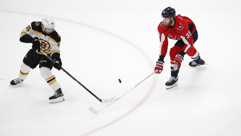 May 23, 2021; Washington, District of Columbia, USA; Boston Bruins defenseman Matt Grzelcyk (48) battles for the puck with Washington Capitals right wing Anthony Mantha (39) during the first period in game five of the first round of the 2021 Stanley Cup Playoffs at Capital One Arena. Mandatory Credit: Amber Searls-USA TODAY Sports