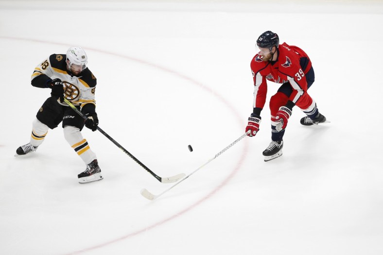 May 23, 2021; Washington, District of Columbia, USA; Boston Bruins defenseman Matt Grzelcyk (48) battles for the puck with Washington Capitals right wing Anthony Mantha (39) during the first period in game five of the first round of the 2021 Stanley Cup Playoffs at Capital One Arena. Mandatory Credit: Amber Searls-USA TODAY Sports