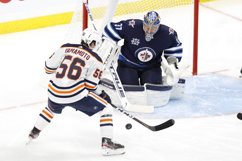May 23, 2021; Winnipeg, Manitoba, CAN; Edmonton Oilers right wing Kailer Yamamoto (56) sets to shoot on Winnipeg Jets goaltender Connor Hellebuyck (37) in the second period in game three of the first round of the 2021 Stanley Cup Playoffs at Bell MTS Place. Mandatory Credit: James Carey Lauder-USA TODAY Sports