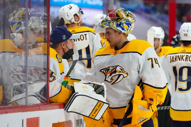 May 17, 2021; Raleigh, North Carolina, USA; Nashville Predators goaltender Juuse Saros (74) and goaltender Pekka Rinne (35) talk at the bench against the Carolina Hurricanes in game one of the first round of the 2021 Stanley Cup Playoffs at PNC Arena. Mandatory Credit: James Guillory-USA TODAY Sports