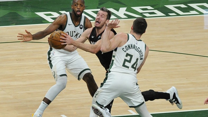 May 24, 2021; Milwaukee, Wisconsin, USA; Miami Heat guard Goran Dragic (7) drives to the basket between Milwaukee Bucks forward Khris Middleton (22) and guard Pat Connaughton (24) in the second quarter during game two in the first round of the 2021 NBA Playoffs at Fiserv Forum. Mandatory Credit: Michael McLoone-USA TODAY Sports