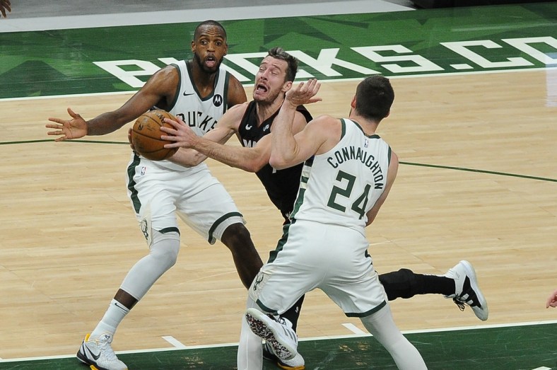 May 24, 2021; Milwaukee, Wisconsin, USA; Miami Heat guard Goran Dragic (7) drives to the basket between Milwaukee Bucks forward Khris Middleton (22) and guard Pat Connaughton (24) in the second quarter during game two in the first round of the 2021 NBA Playoffs at Fiserv Forum. Mandatory Credit: Michael McLoone-USA TODAY Sports