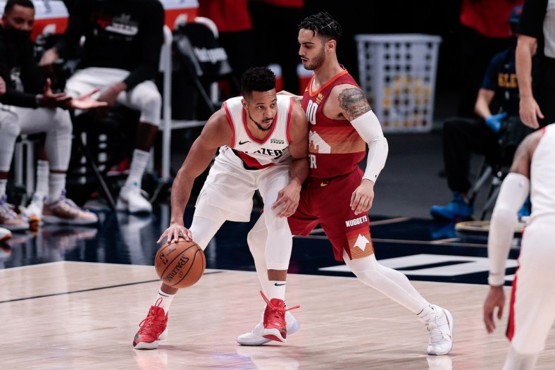 May 24, 2021; Denver, Colorado, USA; Portland Trail Blazers guard CJ McCollum (3) controls the ball as Denver Nuggets guard Markus Howard (00) guards in the second quarter during game two in the first round of the 2021 NBA Playoffs at Ball Arena. Mandatory Credit: Isaiah J. Downing-USA TODAY Sports