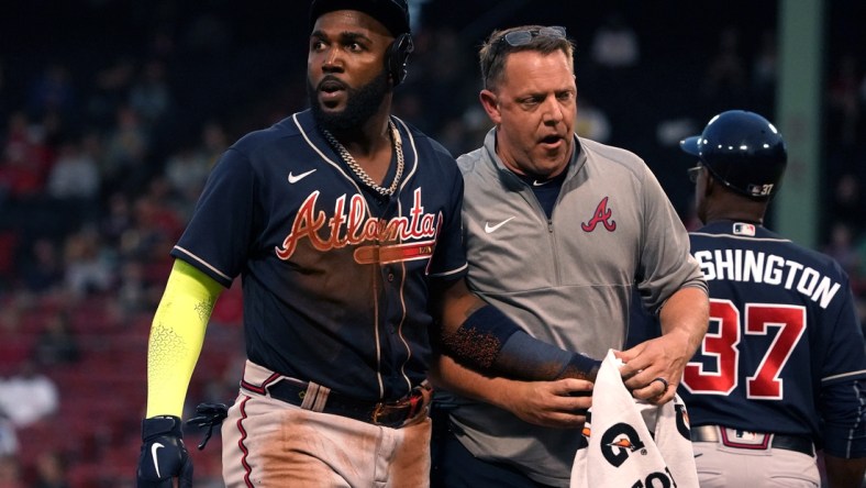 May 25, 2021; Boston, Massachusetts, USA; Atlanta Braves left fielder Marcell Ozuna (left) is assisted by a trainer after being injured against the Boston Red Sox during the third inning at Fenway Park. Mandatory Credit: David Butler II-USA TODAY Sports