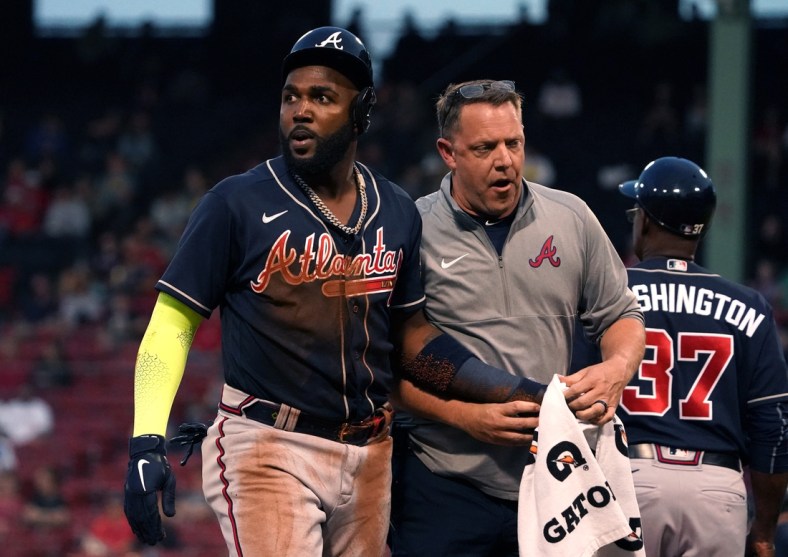 May 25, 2021; Boston, Massachusetts, USA; Atlanta Braves left fielder Marcell Ozuna (left) is assisted by a trainer after being injured against the Boston Red Sox during the third inning at Fenway Park. Mandatory Credit: David Butler II-USA TODAY Sports