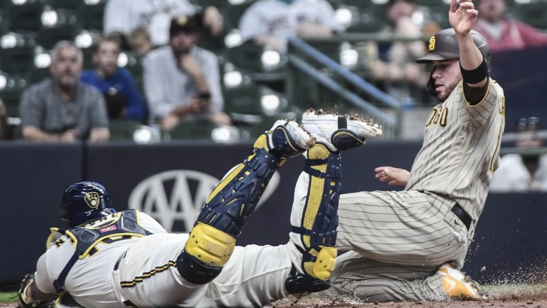 May 25, 2021; Milwaukee, Wisconsin, USA; San Diego Padres catcher Victor Caratini (right) scores on a double steal during the third inning as Milwaukee Brewers catcher Omar Narvaez (left) attempts to make a tag at American Family Field. Mandatory Credit: Benny Sieu-USA TODAY Sports