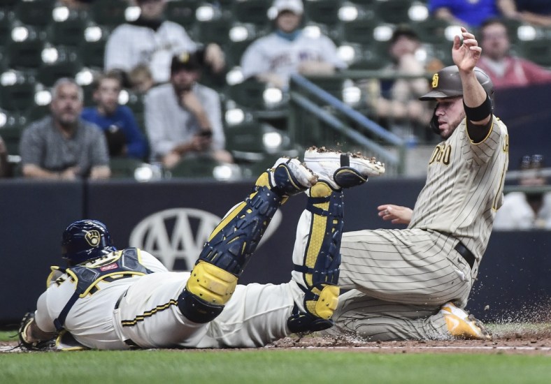 May 25, 2021; Milwaukee, Wisconsin, USA; San Diego Padres catcher Victor Caratini (right) scores on a double steal during the third inning as Milwaukee Brewers catcher Omar Narvaez (left) attempts to make a tag at American Family Field. Mandatory Credit: Benny Sieu-USA TODAY Sports