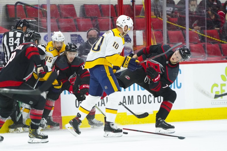May 25, 2021; Raleigh, North Carolina, USA; Nashville Predators center Colton Sissons (10) checks Carolina Hurricanes left wing Steven Lorentz (78) during the first period in game five of the first round of the 2021 Stanley Cup Playoffs at PNC Arena. Mandatory Credit: James Guillory-USA TODAY Sports