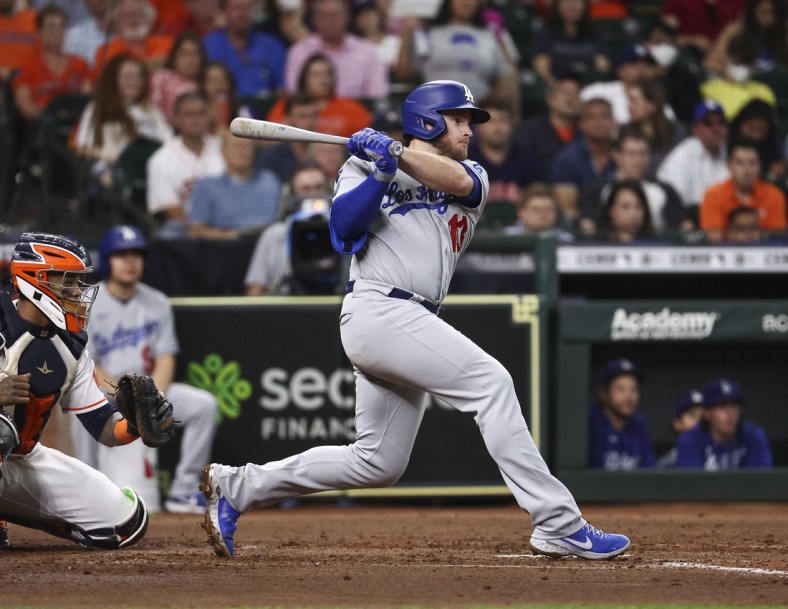 May 26, 2021; Houston, Texas, USA; Los Angeles Dodgers second baseman Max Muncy (13) hits an RBI single during the third inning against the Houston Astros at Minute Maid Park. Mandatory Credit: Troy Taormina-USA TODAY Sports