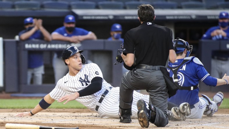 May 27, 2021; Bronx, New York, USA;  New York Yankees designated hitter Aaron Judge (99) is tagged out at home by Toronto Blue Jays catcher Danny Jansen (9) in the first inning at Yankee Stadium. Mandatory Credit: Wendell Cruz-USA TODAY Sports