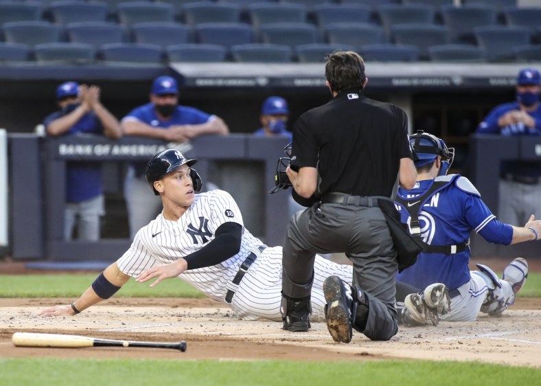 May 27, 2021; Bronx, New York, USA;  New York Yankees designated hitter Aaron Judge (99) is tagged out at home by Toronto Blue Jays catcher Danny Jansen (9) in the first inning at Yankee Stadium. Mandatory Credit: Wendell Cruz-USA TODAY Sports