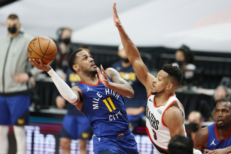 May 27, 2021; Portland, Oregon, USA; Denver Nuggets point guard Monte Morris (11) shoots the ball against Portland Trail Blazers shooting guard CJ McCollum (3) during the first half of game three in the first round of the 2021 NBA Playoffs at Moda Center. Mandatory Credit: Soobum Im-USA TODAY Sports