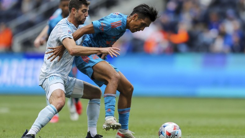 May 29, 2021; Cincinnati, OH, USA; New England Revolution midfielder Matt Polster (8) battles for the ball against FC Cincinnati forward Yuya Kubo (7) in the first half at TQL Stadium. Mandatory Credit: Katie Stratman-USA TODAY Sports