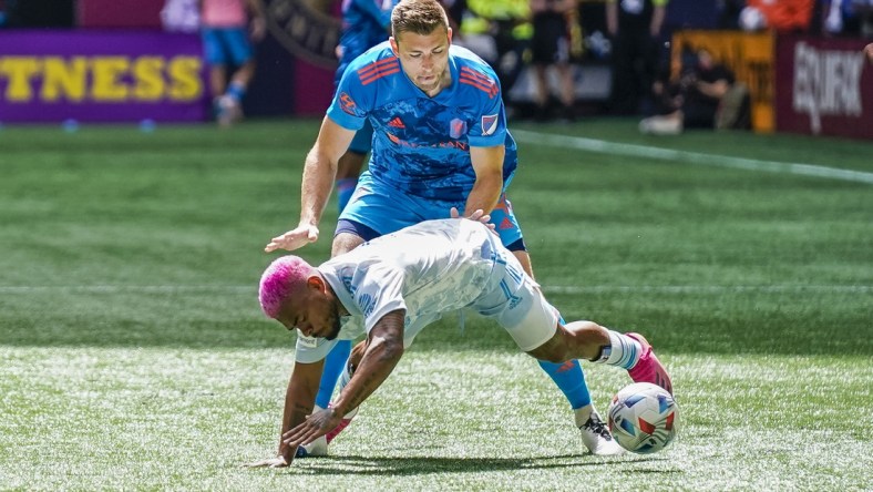 May 29, 2021; Atlanta, Georgia, USA; Atlanta United forward Josef Martinez (7) is knocked down by Nashville SC defender Dave Romney (4) during the first half at Mercedes-Benz Stadium. Mandatory Credit: Dale Zanine-USA TODAY Sports