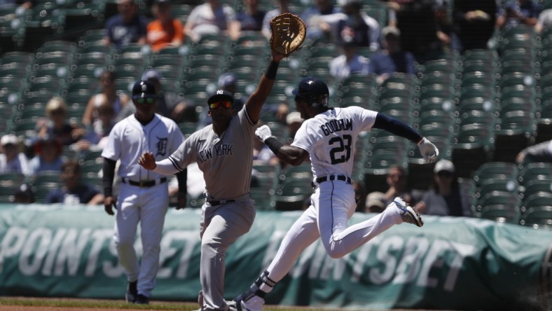 May 30, 2021; Detroit, Michigan, USA; Detroit Tigers center fielder Niko Goodrum (28) safe at first base on a wild throw to New York Yankees first baseman Miguel Andujar (41) during the first inning at Comerica Park. Mandatory Credit: Raj Mehta-USA TODAY Sports