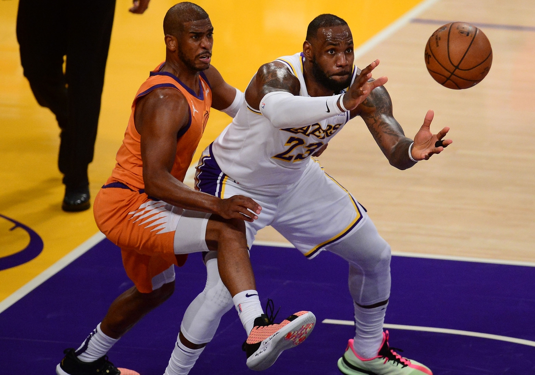 May 30, 2021; Los Angeles, California, USA; Los Angeles Lakers forward LeBron James (23) gets the ball against the defense of Phoenix Suns guard Chris Paul (3) during the second half in game four of the first round of the 2021 NBA Playoffs. at Staples Center. Mandatory Credit: Gary A. Vasquez-USA TODAY Sports