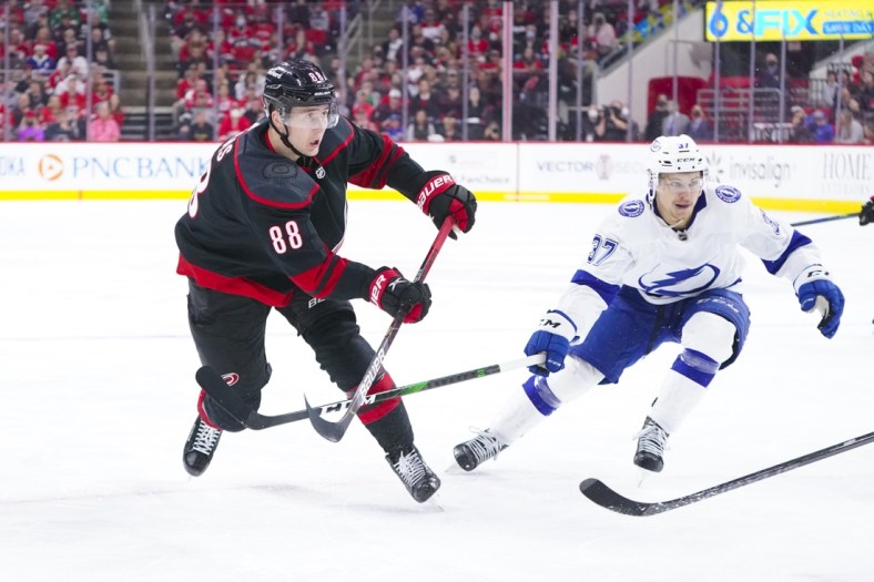 May 30, 2021; Raleigh, North Carolina, USA; Carolina Hurricanes center Martin Necas (88) takes a shot against Tampa Bay Lightning center Yanni Gourde (37) in game one of the second round of the 2021 Stanley Cup Playoffs at PNC Arena. Mandatory Credit: James Guillory-USA TODAY Sports