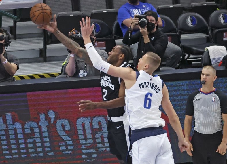 May 30, 2021; Dallas, Texas, USA; LA Clippers forward Kawhi Leonard (2) shoots past Dallas Mavericks center Kristaps Porzingis (6) during the first quarter in game four in the first round of the 2021 NBA Playoffs at American Airlines Center. Mandatory Credit: Kevin Jairaj-USA TODAY Sports