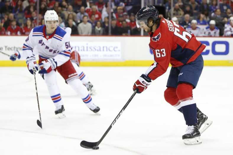 Mar 28, 2018; Washington, DC, USA; Washington Capitals left wing Shane Gersich (63) skates with the puck during his first NHL game in front of New York Rangers center Lias Andersson (50) during the first period at Capital One Arena. Mandatory Credit: Amber Searls-USA TODAY Sports