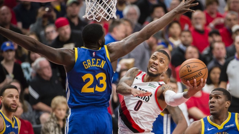 May 20, 2019; Portland, OR, USA; Portland Trail Blazers guard Damian Lillard (0) puts up a shot against Golden State Warriors forward Draymond Green (23) during the second half in game four of the Western conference finals of the 2019 NBA Playoffs at Moda Center. The Warriors won 119-117 in overtime. Mandatory Credit: Troy Wayrynen-USA TODAY Sports