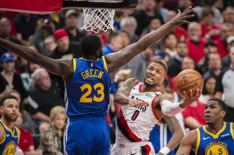 May 20, 2019; Portland, OR, USA; Portland Trail Blazers guard Damian Lillard (0) puts up a shot against Golden State Warriors forward Draymond Green (23) during the second half in game four of the Western conference finals of the 2019 NBA Playoffs at Moda Center. The Warriors won 119-117 in overtime. Mandatory Credit: Troy Wayrynen-USA TODAY Sports