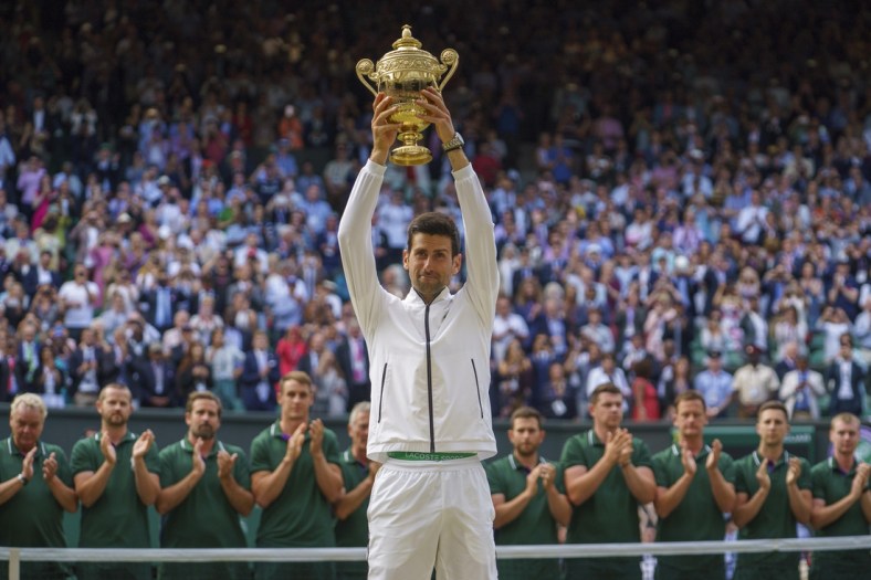 Jul 14, 2019; London, United Kingdom; Novak Djokovic (SRB) lifts the trophy after his mens final match against Roger Federer (SUI) on day 13 at the All England Lawn and Croquet Club. Mandatory Credit: Susan Mullane-USA TODAY Sports
