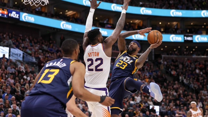 Feb 24, 2020; Salt Lake City, Utah, USA; Utah Jazz forward Royce O'Neale (23) shoots an off-balance shot over Phoenix Suns center Deandre Ayton (22) during the second quarter at Vivint Smart Home Arena. Mandatory Credit: Chris Nicoll-USA TODAY Sports