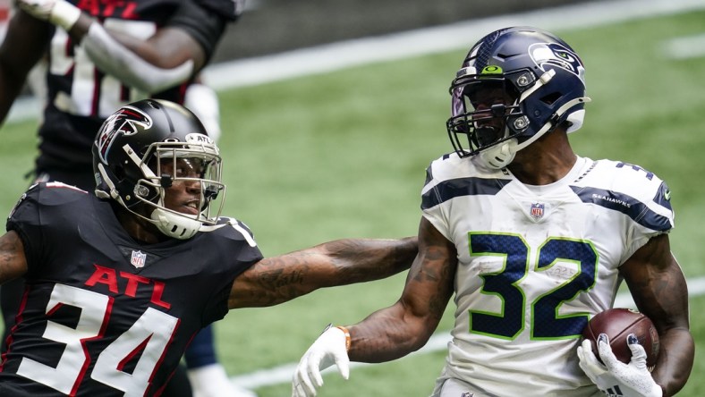 Sep 13, 2020; Atlanta, Georgia, USA; Seattle Seahawks running back Chris Carson (32) runs against Atlanta Falcons defensive back Darqueze Dennard (34) during the first quarter at Mercedes-Benz Stadium. Mandatory Credit: Dale Zanine-USA TODAY Sports