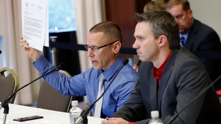 Victims of Dr. Richard Strauss, Brian Garrett, right, listens as Stephen Snyder Hill holds a document from Student Health Services while testifying to the extent of their abuse during an Ohio State University Board of Trustees meeting at the Longaberger Alumni House on Nov. 16, 2018.Mt Trustees Ac 10