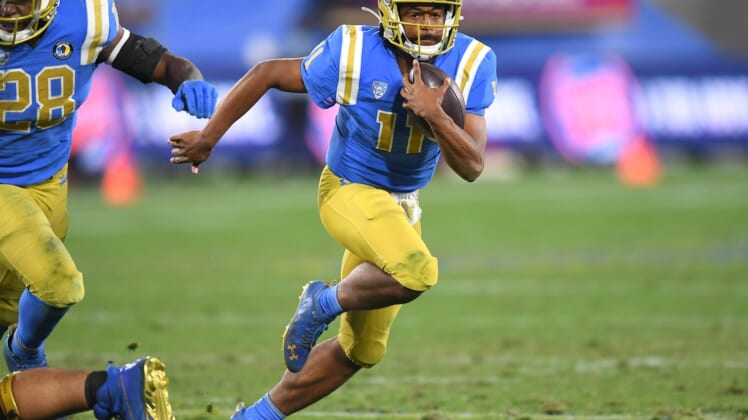 Dec 19, 2020; Pasadena, California, USA; UCLA Bruins quarterback Chase Griffin (11) runs the ball during overtime against the Stanford Cardinal at the Rose Bowl. Mandatory Credit: Jayne Kamin-Oncea-USA TODAY Sports