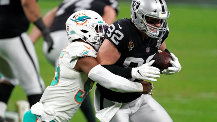 Dec 26, 2020; Paradise, Nevada, USA; Miami Dolphins outside linebacker Jerome Baker (55) tackles Las Vegas Raiders tight end Jason Witten (82) during the first half at Allegiant Stadium. Mandatory Credit: Kirby Lee-USA TODAY Sports