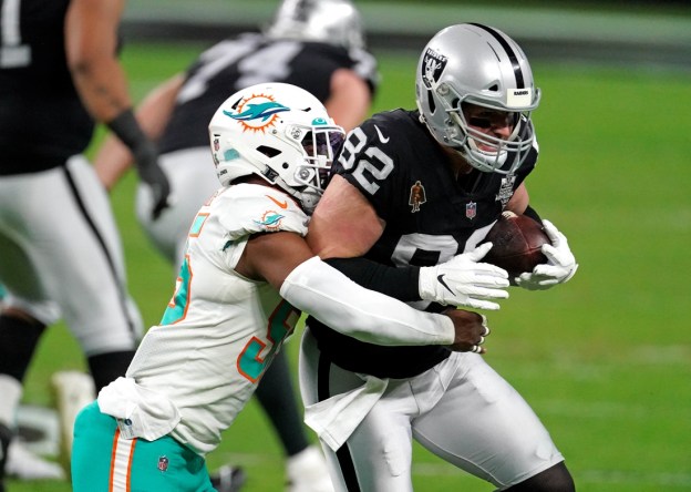 Dec 26, 2020; Paradise, Nevada, USA; Miami Dolphins outside linebacker Jerome Baker (55) tackles Las Vegas Raiders tight end Jason Witten (82) during the first half at Allegiant Stadium. Mandatory Credit: Kirby Lee-USA TODAY Sports