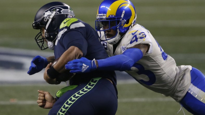 Jan 9, 2021; Seattle, Washington, USA; Los Angeles Rams safety John Johnson III (43) tackles Seattle Seahawks quarterback Russell Wilson (3) during the fourth quarter at Lumen Field. Mandatory Credit: Joe Nicholson-USA TODAY Sports