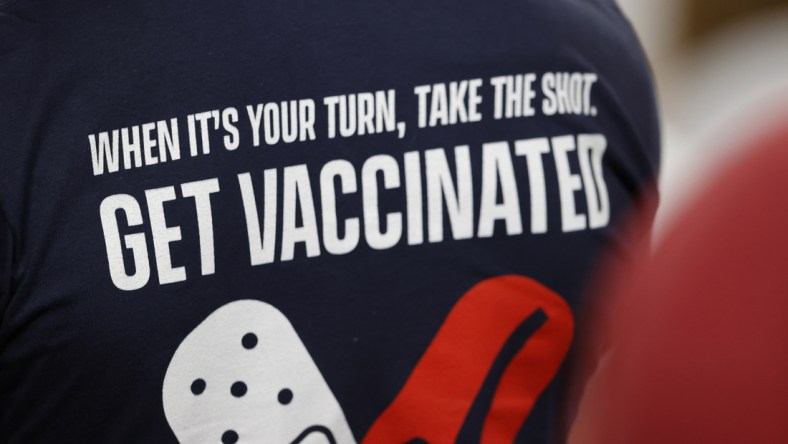 Feb 7, 2020; Tampa, FL, USA; A fan wears a shirt reminding people to get a COVID-19 vaccine during the first quarter of Super Bowl LV between the Kansas City Chiefs and the Tampa Bay Buccaneersat Raymond James Stadium.  Mandatory Credit: Kim Klement-USA TODAY Sports