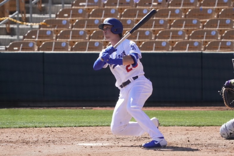 Mar 1, 2021; Glendale, Arizona, USA; Los Angeles Dodgers pinch hitter Andy Burns (29) hits a two run RBI double against the Colorado Rockies in the fourth inning during a spring training game at Camelback Ranch. Mandatory Credit: Rick Scuteri-USA TODAY Sports