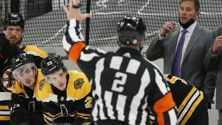 Mar 28, 2021; Boston, Massachusetts, USA; Referee Mike Hasenfratz (2) skates towards Boston Bruins head coach Bruce Cassidy and the Boston bench after Boston had a goal disallowed during the third period of their 1-0 loss to the New Jersey Devils at TD Garden. Mandatory Credit: Winslow Townson-USA TODAY Sports