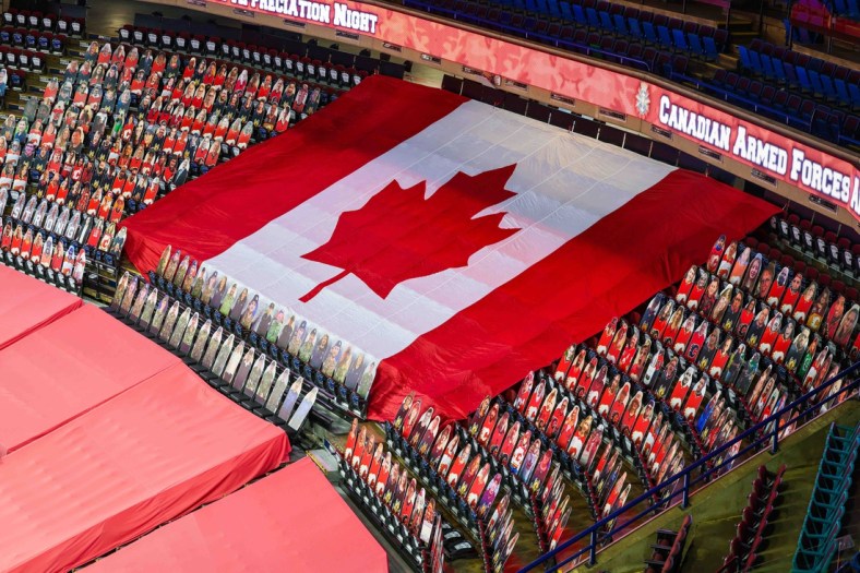Mar 27, 2021; Calgary, Alberta, CAN; General view of cardboard cutouts of Canadian Armed Forces in front of the Canadian flag for the Canadian Armed Forces Appreciation Night prior to the game between the Calgary Flames and the Winnipeg Jets at Scotiabank Saddledome. Mandatory Credit: Sergei Belski-USA TODAY Sports